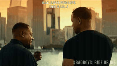 Two Men Standing In Front Of City Skyline GIF
