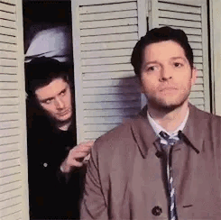 Two Men Standing In Front Of Closet GIF