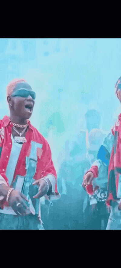 Two Men Standing In Front Of Crowd One Wearing Sunglasses GIF