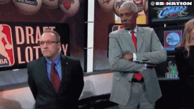 Two Men Standing In Front Of Draft Lottery Sign GIF