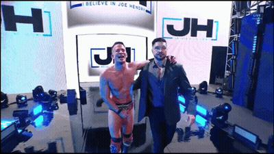 Two Men Standing In Front Of JH Sign GIF