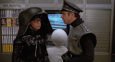 Two Men Standing In Front Of Mr Rental Sign GIF