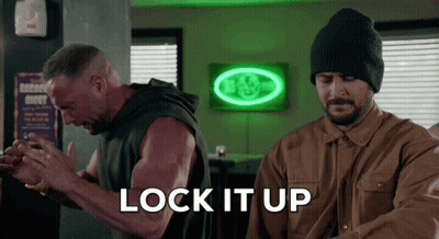 Two Men Standing In Front Of Neon Lock It Up Sign GIF