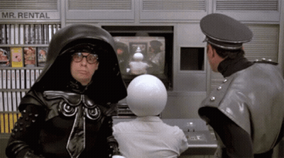Two Men Standing In Front Of Rental Machine GIF