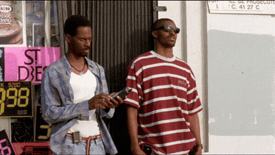 Two Men Standing In Front Of St. Dxe Sign GIF