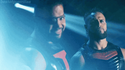 Two Men Standing In Front Of Talla Tonga Sign GIF