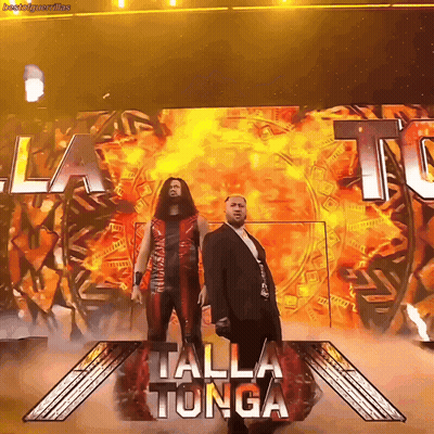 Two Men Standing In Front Of Talla Tonga Sign GIF