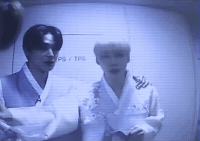 Two Men Standing In Front Of TPS Wall GIF