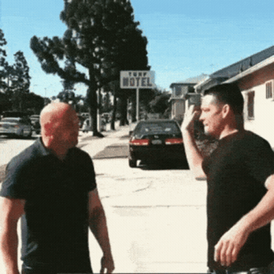 Two Men Standing In Front Of Turf Motel Sign GIF