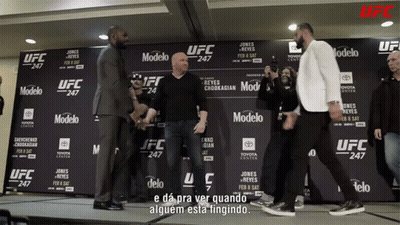 Two Men Standing In Front Of UFC Sign GIF