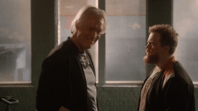 Two Men Standing In Front Of Window Talking GIF