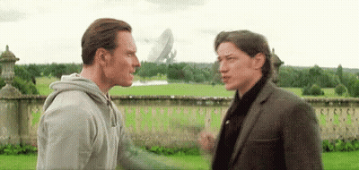 Two Men Standing In Grassy Field GIF