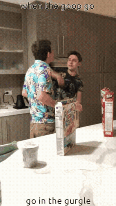 Two Men Standing In Kitchen With Cereal Box GIF