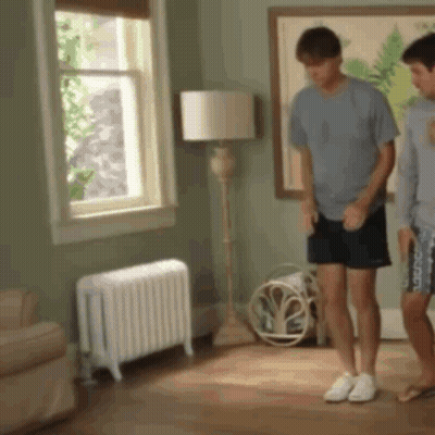 Two Men Standing in Living Room With Radiator