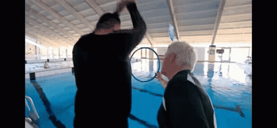 Two Men Standing In Pool Looking At Ring GIF