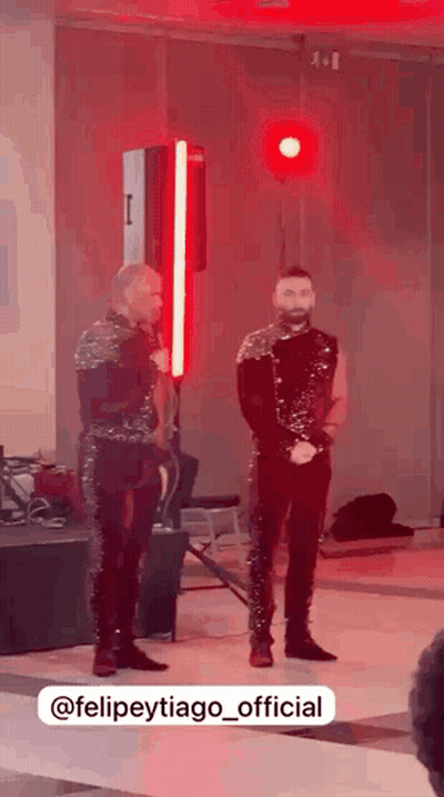 Two Men Standing In Red-Lit Room GIF