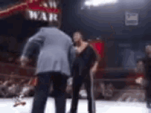 Two Men Standing In Ring With Sign War GIF