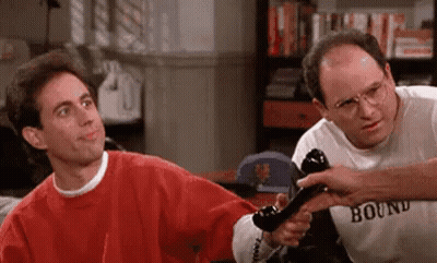 Two Men Standing In Room One Holding Phone GIF
