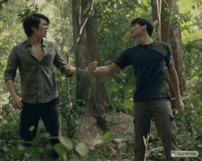 Two Men Standing In The Woods With Kapwing Written On The Bottom Left GIF