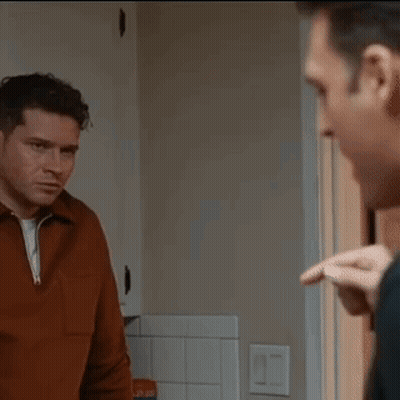 Two Men Standing Looking At Each Other GIF