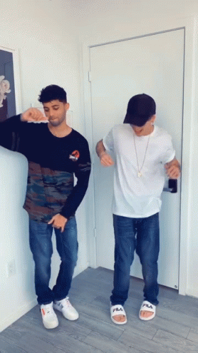 Two Men Standing Near Door With Fila Sandals GIF