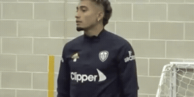 Two Men Standing Next To Brick Wall GIF