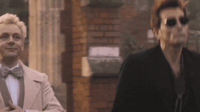 Two Men Standing Next To Brick Wall GIF
