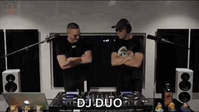 Two Men Standing Next to DJ Mixer