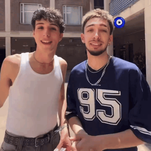 Two Men Standing Next To Each Other GIF
