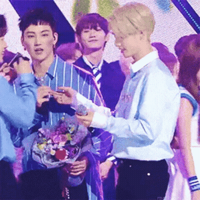 Two Men Standing Next To Each Other Holding Microphone On Stage GIF