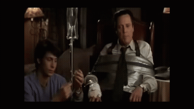 Two Men Standing Next To Each Other In A Dark Room GIF