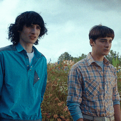 Two Men Standing Next To Each Other In A Field GIF