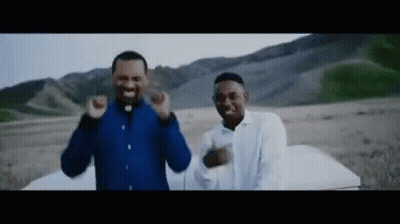 Two Men Standing Next To Each Other In A Field GIF
