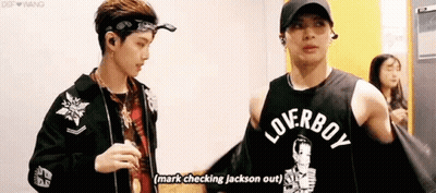 Two Men Standing Next To Each Other In A Room GIF