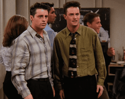 Two Men Standing Next To Each Other In A Room GIF