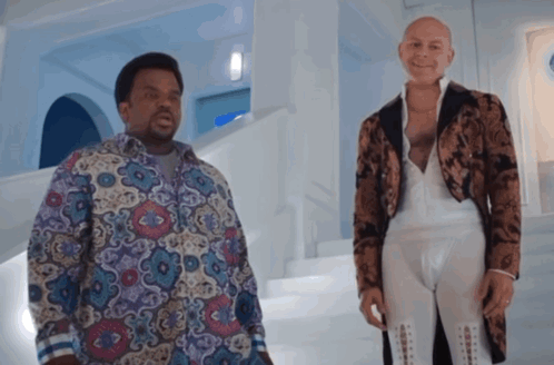 Two Men Standing Next To Each Other In A Room GIF