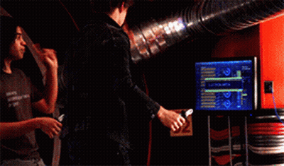 Two Men Standing Next To Each Other In A Room With A Blue Pipe In The Background GIF