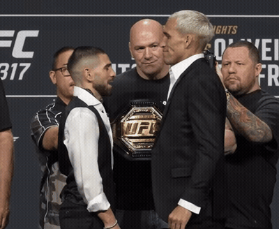 Two Men Standing Next To Each Other In Front Of A Sign That Says Ufc 317 GIF