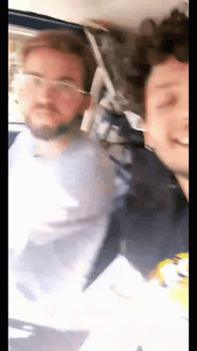 Two Men Standing Next To Each Other On Bus One Wearing Glasses GIF