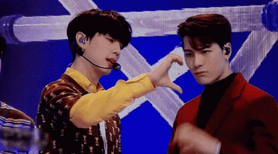 Two Men Standing Next To Each Other On Stage GIF