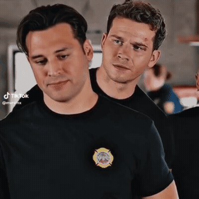 Two Men Standing Next To Each Other One In Firefighter Shirt GIF