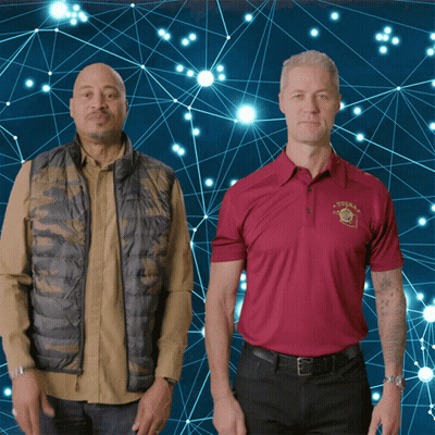 Two Men Standing Next To Each Other One Wearing Texas Shirt GIF