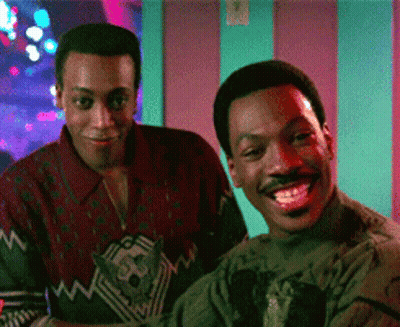 Two Men Standing Next To Each Other Smiling GIF