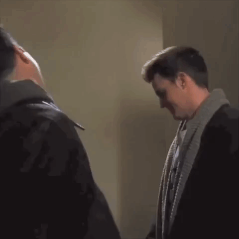Two Men Standing Next To Each Other Talking GIF