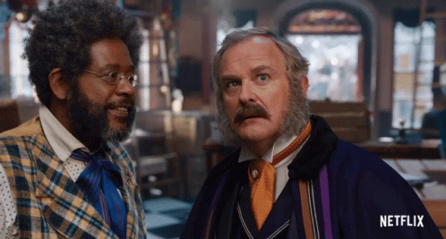 Two Men Standing Next To Each Other With A Netflix Logo On The Bottom Right GIF