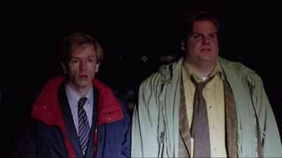 Two Men Standing Next To Each Other With One Wearing A Yellow Shirt And Tie GIF