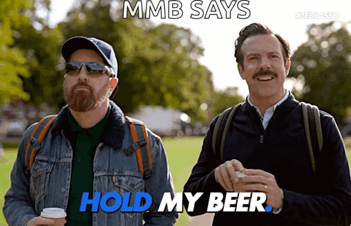 Two Men Standing Next To Each Other With The Words Mmb Says Hold My Beer GIF