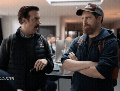 Two Men Standing Next To Each Other With Word Producer GIF