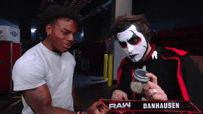 Two Men Standing Next To Raw Danhausen Sign GIF