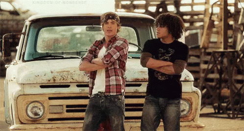 Two Men Standing Next To Truck With Arms Crossed GIF